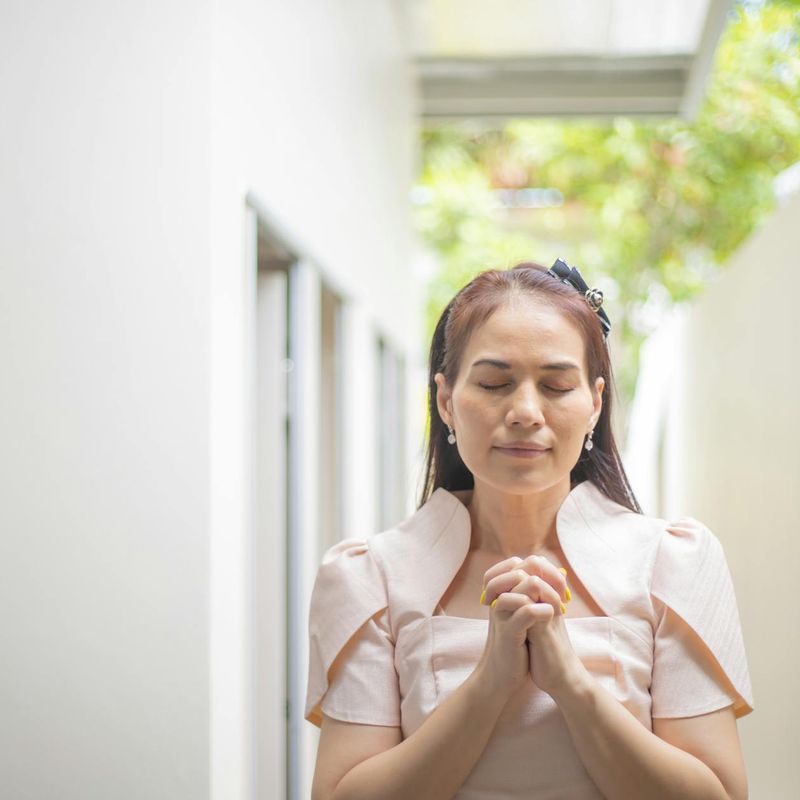 Person meditating peacefully outdoors with a calm and focused expression.