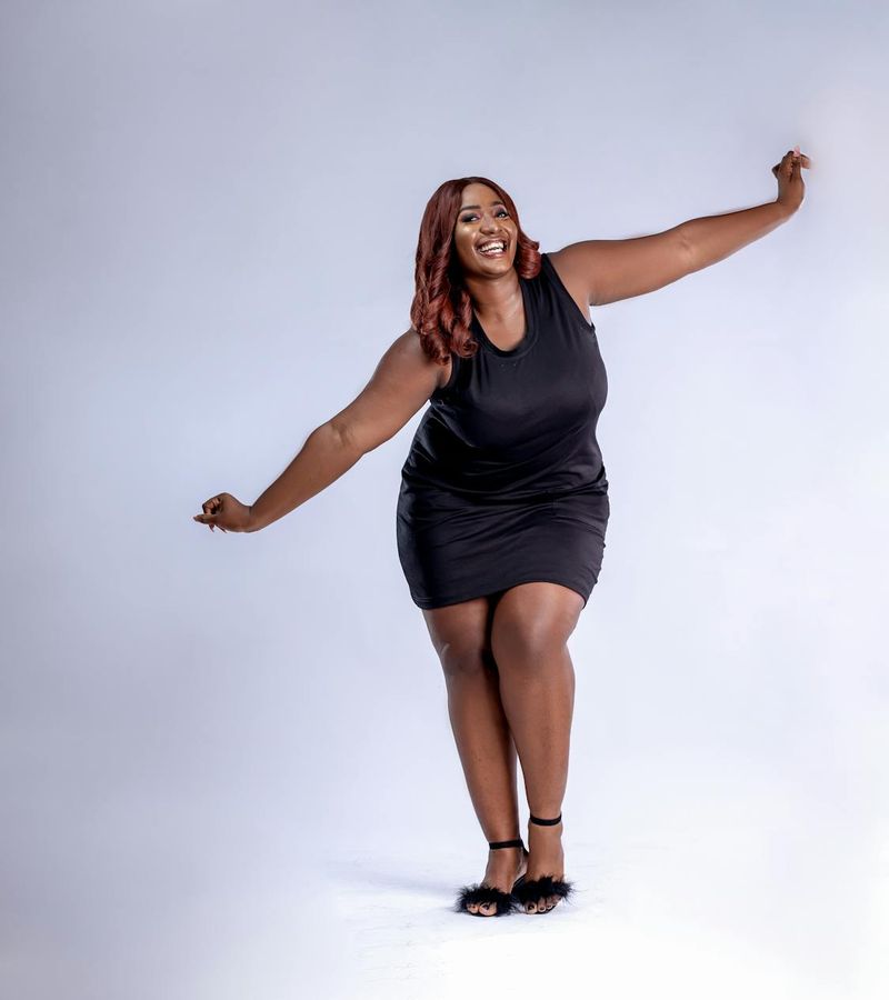 Woman with athletic wear smiling and feeling energetic in a bright studio.